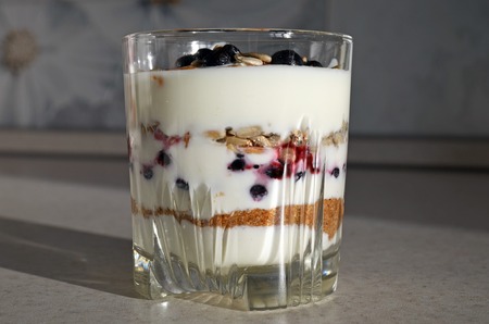 Healthy yogurt with mix of berry, sunflower seeds, bran and honey for healthy morning meal. Selective focusの写真素材