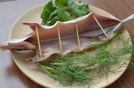 Dried omul on a wooden plate, decorated with verdureの写真素材