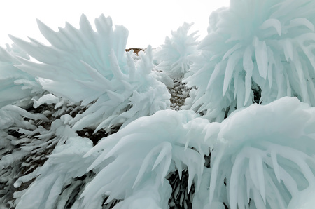 Ice splashes of waves on shores of Baikal, Ice blocks and icicles on coast rocks.