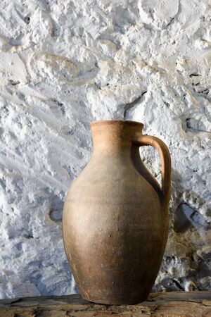 Old georgian clay jug on shelf against background of old stone wallの写真素材