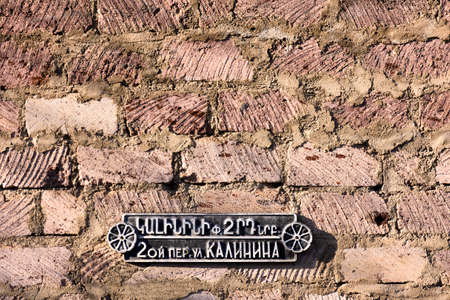 Dilijan, Armenia-May, 02 2019: sign with street name and house number on brick wall, Armeniaのeditorial素材