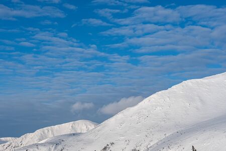 Cold winter day, spring, March, mountain range in the sunshine