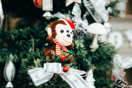 Christmas toy brown monkey sitting on Christmas treeの写真素材