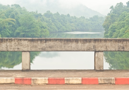 The fence of bridge and scenic over river and mountain be full of fog