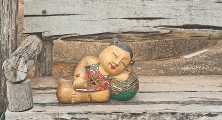 Asian style sleeping wood doll on wooden swing , Asia souvenirの写真素材