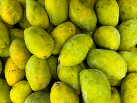 Close-up of Fresh Yellow Mangoes in a Vibrant Pileの写真素材