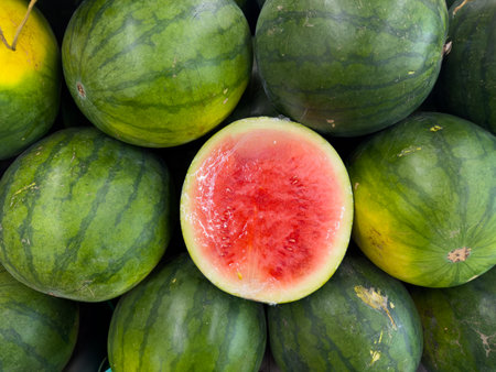 Top view of fresh whole and sliced watermelons in a market displayの写真素材