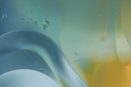 Abstract pattern of colored oil bubbles on water