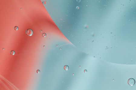 Abstract pattern of colored oil bubbles on water