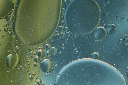 Abstract pattern of colored oil bubbles on water