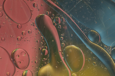 Abstract pattern of colored oil bubbles on waterの写真素材