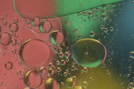 Abstract pattern of colored oil bubbles on waterの写真素材