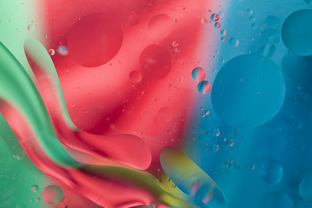 Abstract pattern of colored oil bubbles on water
