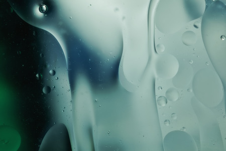 Abstract pattern of colored oil bubbles on waterの写真素材