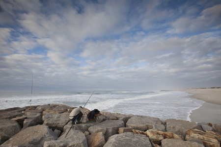 Fishermen standing on the rocksの写真素材