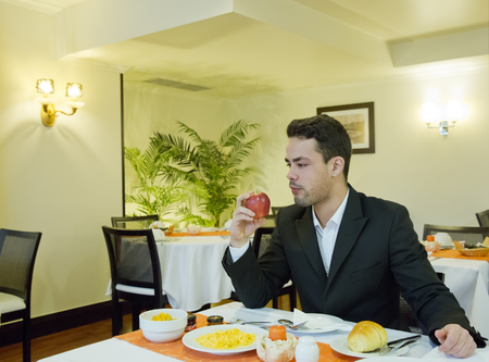 Businessman takes breakfast in hotelの写真素材