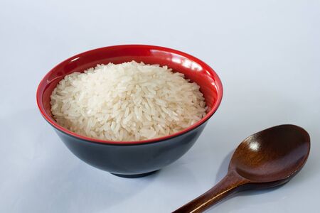rice in a bowl and spoon on white backgroundの写真素材