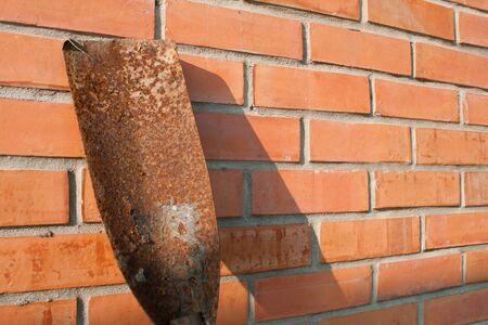 spade shovel on red brick wallの写真素材