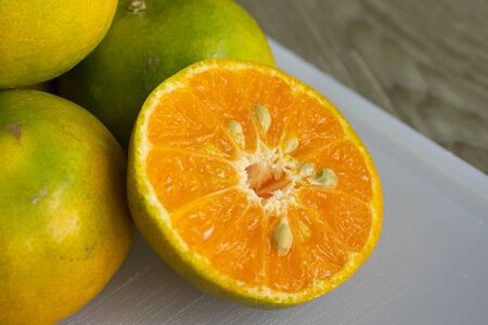 slice of orange fruit  on white cutting boardの写真素材