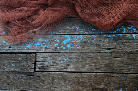 Red trawl put on plank floor with blue paint drops.