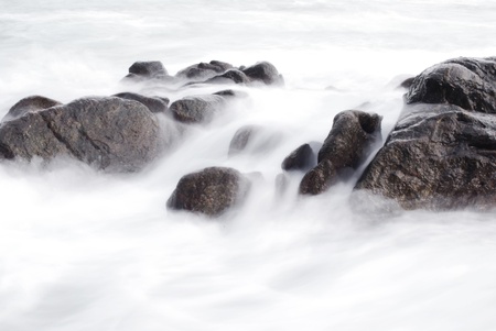 clean white wave through black rock , seascapeの写真素材