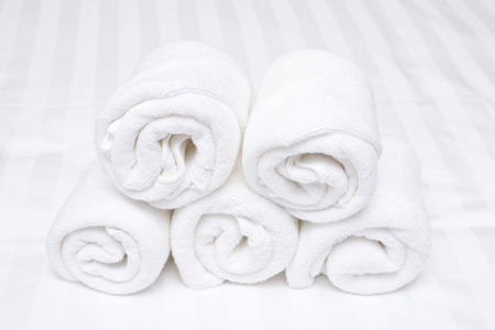 white roll towel on bedの写真素材