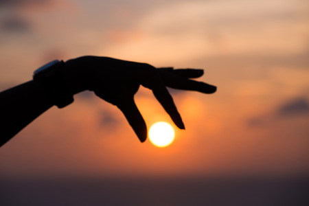 the hand grab the sun in sunset time, Phuket Thailandの写真素材