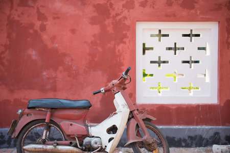 Old motorcycle with red wallsの写真素材