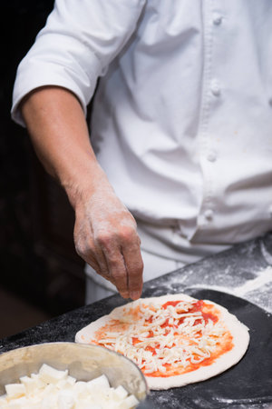Chefs are sprinkle cheese onto a pizza, foodの写真素材