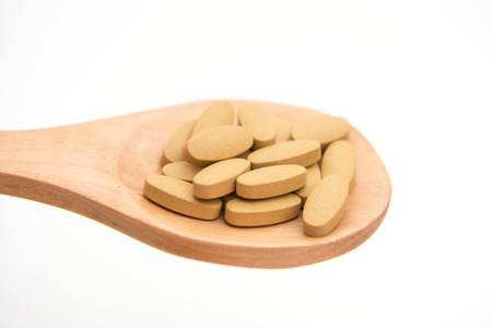 drug tablet on wood ladle for sick people, medicineの写真素材