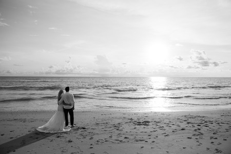 lovers are looking the sunset on the beach, black and whiteの写真素材
