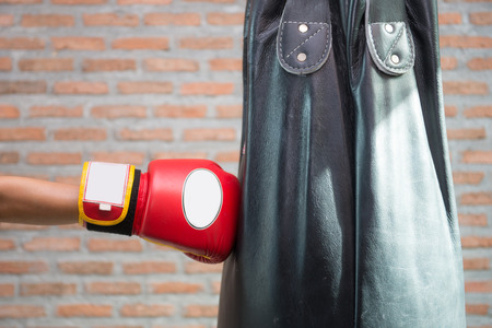 Boxer in red boxing gloves is punching a sandbagの写真素材