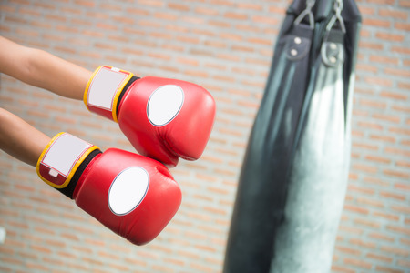 Boxer in red boxing gloves is punching a sandbagの写真素材