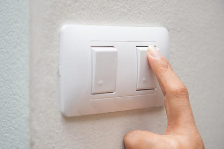 a woman press off light switch, powerの写真素材