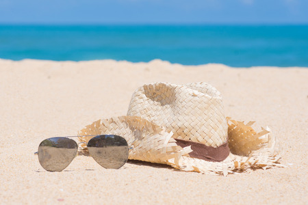 woven hats and sunglasses on the beach, fashionの写真素材