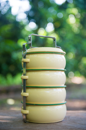 Yellow metal carrier food placed on a wooden, boxの写真素材