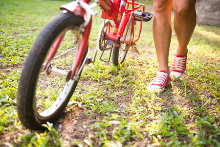 girl is holding bicycles in park, bikeの写真素材