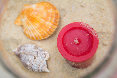 Seashells and candles decorated in jar, sandの写真素材