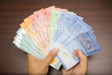 hand holding with Malaysian money banknotes, ringgit