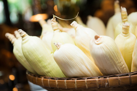 sweet corn with leaves in the basket, foodの写真素材