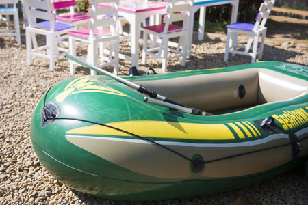 green inflatable boat on the bank of the river, outdoor