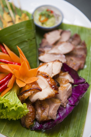 charcoal-boiled pork neck with vegetable on banana leafの写真素材