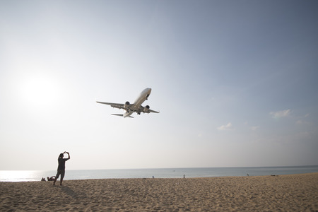 PHUKET, THAILAND - FEBRUARY 9, 2016 : airplane flying over beautiful beach at Mai Khao Beach, Phuket...