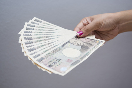 female hand holding japanese money banknotes, yenの写真素材