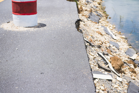 Damage of asphalt road, cracked and brokenの写真素材