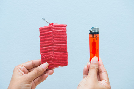 Red firecrackers and a lighter in hand, dangerousの写真素材