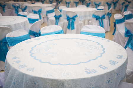 set of tables and chair with blue bow on wedding dayの写真素材