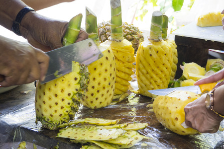 person's hand peeling pineapple, fruitの写真素材