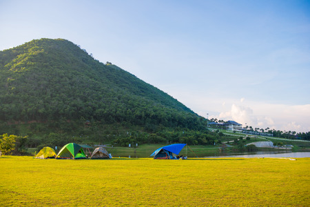 Tents camping on grass field beside the river, outdoorの写真素材