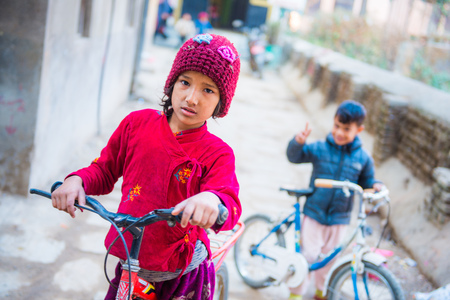Nepal - 22 december 2016 :: Nepalese girl and boy ride the bike , kidsのeditorial素材